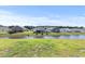 Picturesque backyard view features a tranquil pond, green lawn, and neighboring houses at 153 Foxford Dr., Conway, SC 29526
