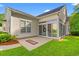 Home exterior showcasing sunroom, patio, and well-manicured lawn at 1617 Tradition Club Dr., Pawleys Island, SC 29585