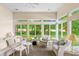 Bright sunroom with floor to ceiling windows and comfortable wicker furniture at 1617 Tradition Club Dr., Pawleys Island, SC 29585