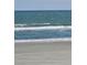Beach scene with waves breaking on the shore and a yellow raft floating in the water at 1625 S Ocean Blvd. # 106, North Myrtle Beach, SC 29582
