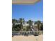 Scenic beach view from a balcony with palm trees and lounge chairs for relaxing in a sunny place at 1625 S Ocean Blvd. # 106, North Myrtle Beach, SC 29582