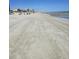 Expansive beach scene with tire tracks in the sand leading toward the ocean and distant buildings at 1625 S Ocean Blvd. # 106, North Myrtle Beach, SC 29582