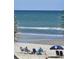 Beachside scene of people relaxing on the sand with chairs and umbrellas with the ocean in the background at 1625 S Ocean Blvd. # 106, North Myrtle Beach, SC 29582