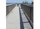 Wide shot of a beach boardwalk leading to the ocean with a lifeguard station at the end of the walkway at 1625 S Ocean Blvd. # 106, North Myrtle Beach, SC 29582