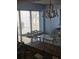Coastal dining area with a glass-top table, decorative chandelier, and natural light streaming through the window at 1625 S Ocean Blvd. # 106, North Myrtle Beach, SC 29582