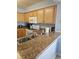 Functional kitchen with stainless steel sink, wooden cabinets, granite countertops and modern appliances at 1625 S Ocean Blvd. # 106, North Myrtle Beach, SC 29582
