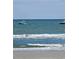 Ocean view with waves breaking near the beach and boats floating in the distance at 1625 S Ocean Blvd. # 106, North Myrtle Beach, SC 29582