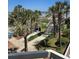 Elevated view of a landscaped walkway to the beach and a building's pool area under palm trees at 1625 S Ocean Blvd. # 106, North Myrtle Beach, SC 29582