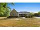 Expansive backyard with an open lawn, a fence, lush trees, and a glimpse of outdoor structures at 1676 Elder Ln., Galivants Ferry, SC 29544