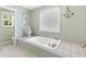 Large bathtub with tile accents and surrounding shelving at 1676 Elder Ln., Galivants Ferry, SC 29544
