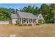 Charming home with a covered front porch, manicured landscaping, and mature trees, exuding curb appeal at 1676 Elder Ln., Galivants Ferry, SC 29544