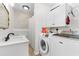 Bright laundry room featuring a white washer and dryer set, modern cabinets, and tasteful floral wallpaper at 1676 Elder Ln., Galivants Ferry, SC 29544