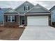 Charming single-Gathering home featuring a stone facade, light blue accents, a two-car garage, and a concrete driveway at 1836 Hardwood Ct., Conway, SC 29526