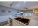 Well-lit kitchen features stainless steel sink, white countertops and cabinetry with an open view to living area at 1900 Duffy St. # A8, North Myrtle Beach, SC 29582