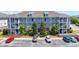 Three-story condo building featuring multiple balconies, a landscaped courtyard, and ample parking at 200 Castle Dr. # 1369, Myrtle Beach, SC 29579
