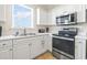 Well-lit kitchen featuring stainless steel appliances, white cabinetry, and tiled floors at 200 Castle Dr. # 1369, Myrtle Beach, SC 29579