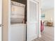 Convenient laundry closet with stacked washer and dryer, plus storage shelves, and access to living room at 200 Castle Dr. # 1369, Myrtle Beach, SC 29579