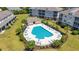 Aerial view of a community pool surrounded by lounge chairs, tables, and lush landscaping at 200 Castle Dr. # 1369, Myrtle Beach, SC 29579