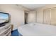 Bright bedroom features a closet, neutral walls, and a TV on top of the dresser at 2000 N Ocean Blvd. # 301, Myrtle Beach, SC 29577