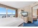 Bright bedroom with balcony access, ocean view, dresser, and a peek into the living area at 2000 N Ocean Blvd. # 301, Myrtle Beach, SC 29577