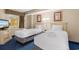 Cozy bedroom with two twin beds, decorative lamps, and beach-themed artwork on the walls at 2000 N Ocean Blvd. # 301, Myrtle Beach, SC 29577