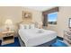 Cozy bedroom with a plush bed, modern lamps, and a window offering natural light and outdoor views at 2000 N Ocean Blvd. # 301, Myrtle Beach, SC 29577