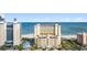 Exterior shot of a large yellow condo building with multiple floors and beach access in Myrtle Beach, South Carolina at 2000 N Ocean Blvd. # 301, Myrtle Beach, SC 29577