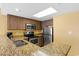 Cozy kitchen features wooden cabinets, granite countertops, and stainless steel appliances at 2000 N Ocean Blvd. # 301, Myrtle Beach, SC 29577
