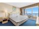 Inviting main bedroom features a comfortable king bed, balcony access with ocean view, and an en-suite bathroom at 2000 N Ocean Blvd. # 301, Myrtle Beach, SC 29577