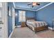 Blue bedroom showcasing a bed, nightstand, and window with plantation shutters at 2004 Crow Field Ct., Myrtle Beach, SC 29579