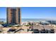 A view from a balcony that looks out over rooftops, a sandy beach, and a large, modern highrise condo building at 204 Maison Dr. # N304, Myrtle Beach, SC 29572
