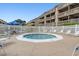 Outdoor pool area with lounge chairs and a round jacuzzi surrounded by a white picket fence on a sunny day at 204 Maison Dr. # N304, Myrtle Beach, SC 29572
