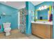A bright bathroom with turquoise walls, decorative accents, vanity with wood drawers, and a yellow-framed mirror at 2100 Sea Mountain Hwy. # 224, North Myrtle Beach, SC 29582
