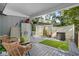 Inviting covered back porch with comfortable wicker seating, potted plants, and an artificial turf rug at 2128 Adams Circle, Little River, SC 29566