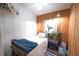 Cozy bedroom with wooden accent wall, bright window, and neutral decor at 2128 Adams Circle, Little River, SC 29566