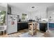 Well-lit kitchen with white cabinets, black countertops, and a functional kitchen island cart at 2128 Adams Circle, Little River, SC 29566