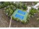 Aerial view of two well-maintained tennis courts surrounded by lush greenery and trees at 2128 Adams Circle, Little River, SC 29566