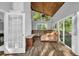 Sunlit living room with vaulted wood ceiling, brick accent wall, and a comfortable leather sectional sofa at 217 Myrtle Ln., Myrtle Beach, SC 29572