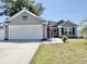 Inviting single-story home with tidy landscaping and a white two car garage door at 2217 Belladora Rd., Conway, SC 29527