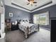 Comfortable bedroom with neutral walls, carpet, and a tray ceiling, filled with light at 224 Castle Dr. # 1408, Myrtle Beach, SC 29579