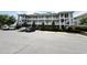 Exterior shot of a multi-story residential building with well-maintained landscaping and parking spaces at 224 Castle Dr. # 1408, Myrtle Beach, SC 29579