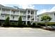 Well-maintained condo building featuring multiple stories, exterior staircases, and green landscaping at 224 Castle Dr. # 1408, Myrtle Beach, SC 29579