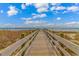Scenic boardwalk leading to a sandy beach with breathtaking ocean views and clear blue sky at 2301 S Ocean Blvd. # 1202, North Myrtle Beach, SC 29582