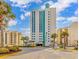 Modern condo building showcasing a desirable location near palm trees and manicured landscaping at 2301 S Ocean Blvd. # 1202, North Myrtle Beach, SC 29582
