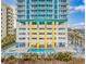 Multi-story building with a pool, colorful accents, and multiple balconies for each unit at 2301 S Ocean Blvd. # 1202, North Myrtle Beach, SC 29582