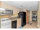 Well-maintained kitchen with light cabinets, essential appliances, and a doorway leading to a bedroom for convenience at 2301 S Ocean Blvd. # 1202, North Myrtle Beach, SC 29582