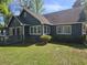 A view of the backyard revealing a cozy deck, verdant lawn, and the home's window-lined exterior at 2333 Brick Dr., Longs, SC 29568