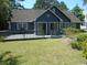 A full view of the home's backyard, featuring a large deck and well-maintained lawn at 2333 Brick Dr., Longs, SC 29568