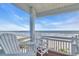View of the ocean and pier from a cozy balcony with outdoor seating at 2808 N Ocean Blvd., North Myrtle Beach, SC 29582