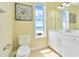 Bathroom showcasing a beach view from the window, with a white vanity and toilet at 2808 N Ocean Blvd., North Myrtle Beach, SC 29582